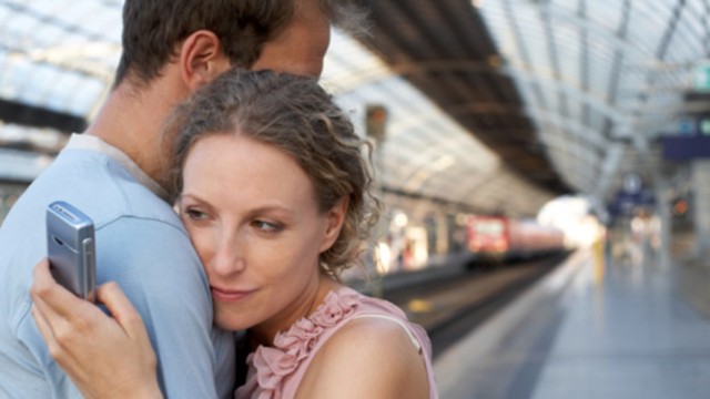 Couple embracing on station platform, woman looking at mobile phone, Separation, Horizontal, Waist Up, Indoors, Side View, Mobile Phone, Caucasian Appearance, Standing, Embracing, Train, Railroad Station, Berlin, Day, Mid Adult, Color Image, Railroad Station Platform, Series, Two People, Mid Adult Men, Mid Adult Women, Distracted, Photography, Mid Adult Couple, Infidelity, Travel, Capital Cities, Wireless Technology, Adults Only, Girlfriend, Boyfriend, msnbc stock photography
