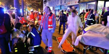 People rest on a bench after being evacuated from the Bataclan theater after a shooting in Paris, Saturday, Nov. 14, 2015. A series of attacks targeting young concert-goers, soccer fans and Parisians enjoying a Friday night out at popular nightspots killed over 100 people in the deadliest violence to strike France since World War II.  (ANSA/AP Photo/Thibault Camus)