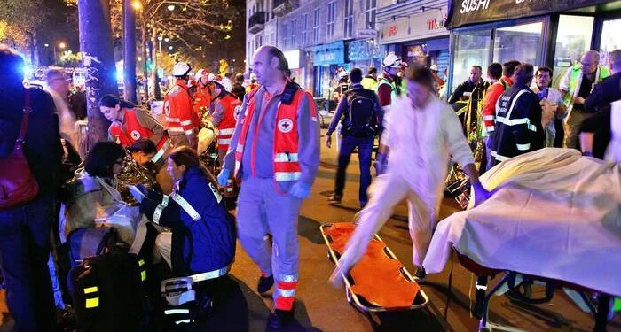 People rest on a bench after being evacuated from the Bataclan theater after a shooting in Paris, Saturday, Nov. 14, 2015. A series of attacks targeting young concert-goers, soccer fans and Parisians enjoying a Friday night out at popular nightspots killed over 100 people in the deadliest violence to strike France since World War II.  (ANSA/AP Photo/Thibault Camus)