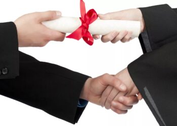 Close up image of graduating student hand accepting diploma against against white background