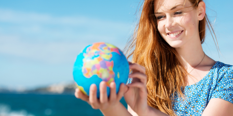 junge frau mit globus am meer