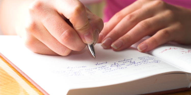 young female is writing notes and planning her schedule