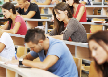 Large group of students writing.