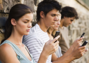 Closeup portrait of young men and women holding cellphone