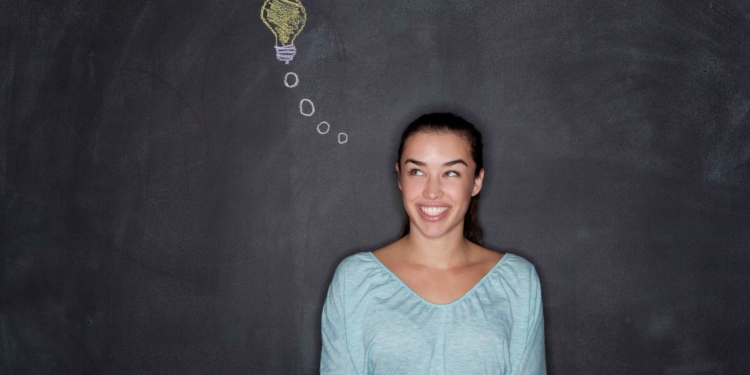 young woman by blackboard with lightbulb