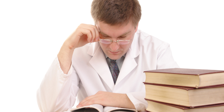 young male doctor studying medical books