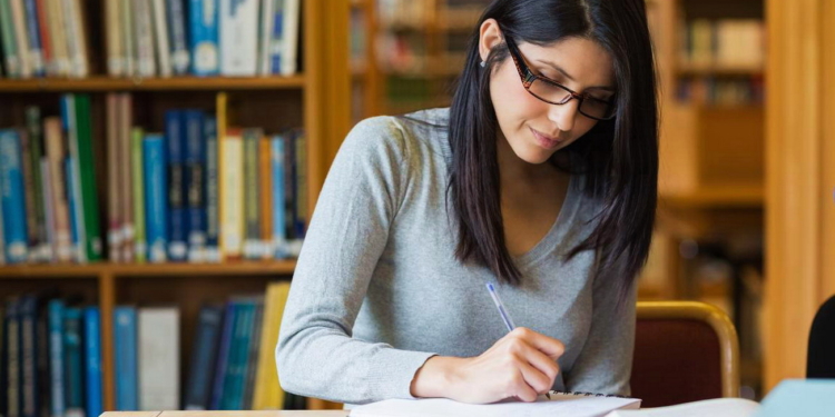 black haired woman studying in the library