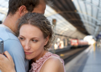 Couple embracing on station platform, woman looking at mobile phone, Separation, Horizontal, Waist Up, Indoors, Side View, Mobile Phone, Caucasian Appearance, Standing, Embracing, Train, Railroad Station, Berlin, Day, Mid Adult, Color Image, Railroad Station Platform, Series, Two People, Mid Adult Men, Mid Adult Women, Distracted, Photography, Mid Adult Couple, Infidelity, Travel, Capital Cities, Wireless Technology, Adults Only, Girlfriend, Boyfriend, msnbc stock photography