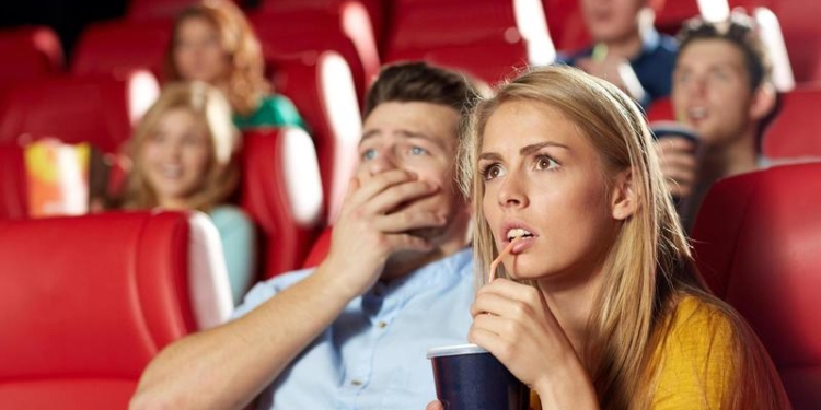 friends watching horror movie in theater