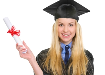 Smiling young woman in graduation gown holding diploma