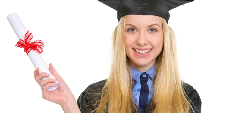 smiling young woman in graduation gown holding diploma