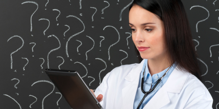 female doctor with digital tablet in front of question marks