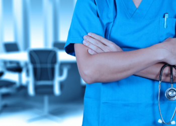 smart doctor with a stethoscope in the hands and office background