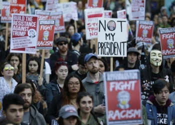 People hold signs as they listen to speakers at a protest against the election of President-elect Donald Trump, Wednesday, Nov. 9, 2016, in downtown Seattle. (ANSA/AP Photo/Ted S. Warren) [CopyrightNotice: Copyright 2016 The Associated Press. All rights reserved.]