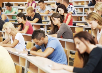 Large group of students writing.