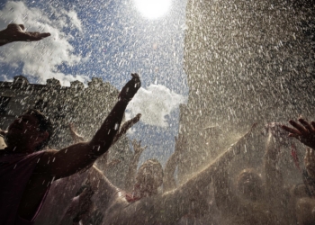 Revelers react as water is thrown from a balcony during the 'Chupinazo', the official opening of the San Fermin fiestas in Pamplona, northern Spain, Wednesday, July 6, 2011. The fiestas 'Los San Fermines' held since 1591, attracts tens of thousands of foreign visitors each year for nine days of revelry, morning bull-runs and afternoon bullfights. (AP Photo/Alvaro Barrientos)