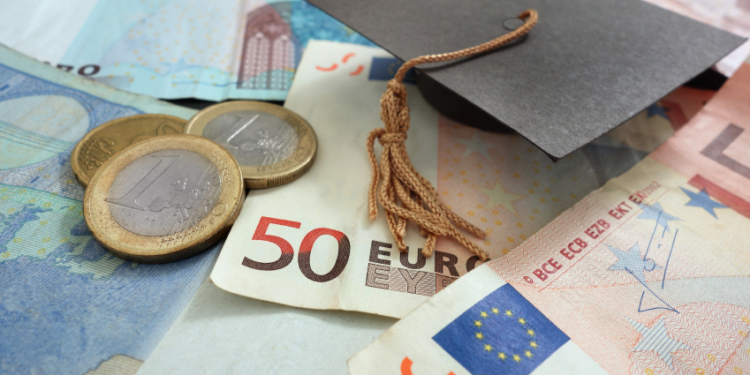 euro notes and coins with mini graduation cap