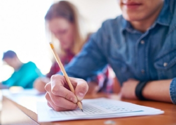 College boy and his fellow students taking a test