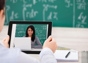 Close-up Of Woman Having Video Chat On Digital Tablet In Classroom