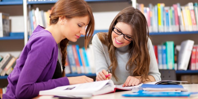 two pretty college students in a libray