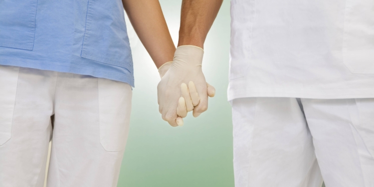 doctor and nurse holding hands in the hospital