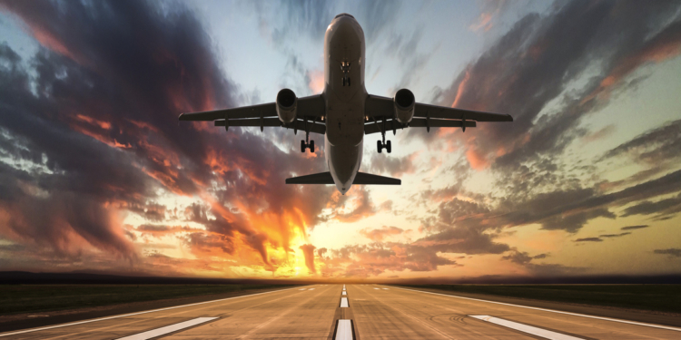 passenger airplane taking off at sunset