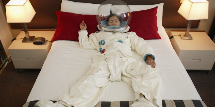 woman dressed in martian suit sleeping in bed