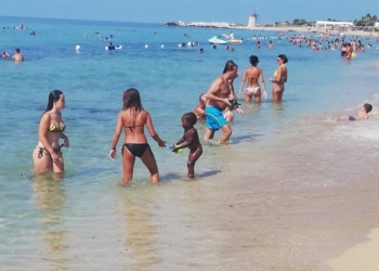 Spiaggia con persone che fanno il bagno