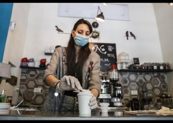 Cameriera al bar prepara caffè d'asporto