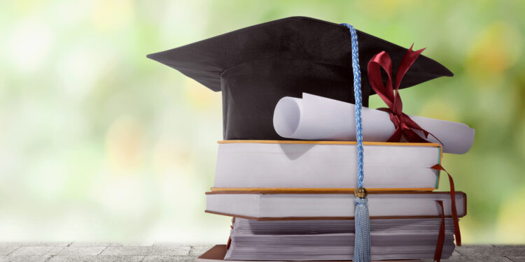 graduation hat with degree paper on a stack of book