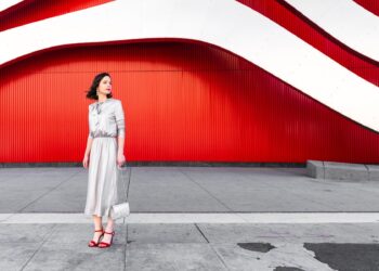 Beautiful glamorous woman in heels at the red wall