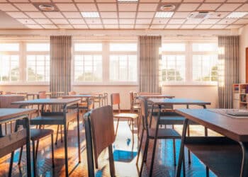 interior of a traditional school classroom with wooden floor and furniture. 3d render