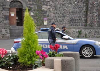In foto un auto della polizia e due poliziotti